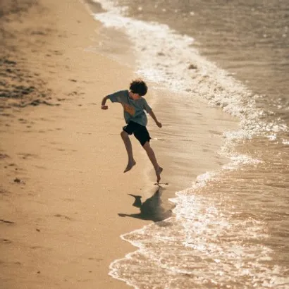 enfant jouant avec les vagues de la mer